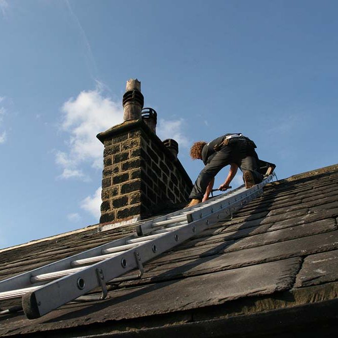 Man using a roof ladder to fix a chimney